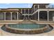 Large freeform pool with cascading waterfalls and a stone patio at 25602 Grandview Pointe, Sorrento, FL 32776