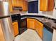 L-shaped kitchen with wood cabinets, stainless steel appliances, and granite countertops at 1916 Lake Atriums Cir # 25, Orlando, FL 32839