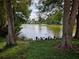Serene lake view with lush green grass and mature trees at 1916 Lake Atriums Cir # 25, Orlando, FL 32839