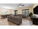 Open living room with gray sectional sofa, dining area, and views to backyard at 1414 Thunderbird Rd, Davenport, FL 33896