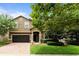 Two-story house with a dark brown garage door and landscaped lawn at 1414 Thunderbird Rd, Davenport, FL 33896