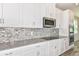 Modern kitchen with white cabinets, gray countertops, and stainless steel appliances at 2260 Sirena Ln, Mount Dora, FL 32757