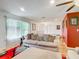 Living room features a comfy sofa, ottoman, and red accent wall at 2281 E Union Cir, Deltona, FL 32725