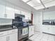 White kitchen with black countertops and appliances, offering ample storage at 2281 E Union Cir, Deltona, FL 32725