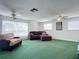 Spacious living room with green carpet, comfy seating, and ceiling fans at 2281 E Union Cir, Deltona, FL 32725