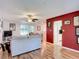 Open living room with hardwood floors, red accent wall, and view to kitchen at 2281 E Union Cir, Deltona, FL 32725