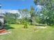 Landscaped backyard with grassy area and mature trees at 2281 E Union Cir, Deltona, FL 32725