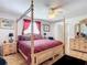 Large bedroom with a wooden post bed, red bedding, and ceiling fan at 2281 E Union Cir, Deltona, FL 32725