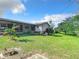 Side yard view showcasing a screened patio and spacious lawn at 2281 E Union Cir, Deltona, FL 32725