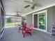 Spacious screened porch, two red chairs and ceiling fans at 2281 E Union Cir, Deltona, FL 32725