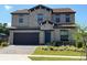 Two-story home with stone and stucco exterior, landscaping, and driveway at 226 Macaulays Cv, Haines City, FL 33844