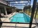 Screened-in rectangular pool with surrounding patio and lounge chairs at 226 Macaulays Cv, Haines City, FL 33844