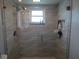 Large walk-in shower with textured tile walls and pebble floor at 11540 Sandy Hill Dr, Orlando, FL 32821