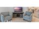 Living room with two armchairs, a TV stand, and a view of the kitchen at 2924 Waterlily Way, Poinciana, FL 34759