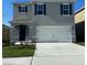 Two-story house with gray siding, white garage door, and blue shutters at 2924 Waterlily Way, Poinciana, FL 34759