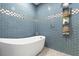 Modern bathroom with a freestanding bathtub and blue tile at 1021 Fantasy Dr, Davenport, FL 33896