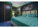 Bedroom with Jurassic World mural and teal bedding at 1021 Fantasy Dr, Davenport, FL 33896