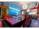 Large dining room with red table and chairs, and a large screen displaying a scenic view at 1021 Fantasy Dr, Davenport, FL 33896