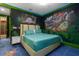 Bedroom with Jurassic World mural and teal bedding at 1021 Fantasy Dr, Davenport, FL 33896