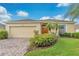 One-story home with a beige exterior, two-car garage and landscaped yard at 503 Balmoral Dr, Davenport, FL 33896