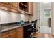 Kitchen with granite countertop and built-in desk area leading to the laundry room at 3499 Rockcliff Pl, Longwood, FL 32779