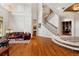 Grand two-story living room featuring hardwood floors, a curved staircase, and a comfortable seating area at 3499 Rockcliff Pl, Longwood, FL 32779