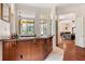 Custom wet bar with granite countertop, wood cabinetry, and views to the living room at 3499 Rockcliff Pl, Longwood, FL 32779