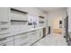 Sleek kitchen featuring white shaker cabinets, marble backsplash, and gold hardware at 734 S Mills Ave, Orlando, FL 32801