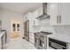 Modern kitchen with white cabinets, marble countertops, and stainless steel appliances at 734 S Mills Ave, Orlando, FL 32801