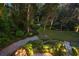 Landscaped garden at night, showcasing meticulously designed pathways and lighting at 1391 Richmond Rd, Winter Park, FL 32789