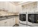 Laundry room with front load washer and dryer and custom cabinets at 1391 Richmond Rd, Winter Park, FL 32789