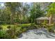 Landscaped backyard with lush greenery and a brick guesthouse at 1391 Richmond Rd, Winter Park, FL 32789