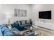 Modern living room features a blue sectional sofa and a large TV at 2602 Sunrise Shores Dr, Kissimmee, FL 34747