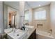 Bathroom with dual sinks, granite countertop, and bathtub at 2602 Sunrise Shores Dr, Kissimmee, FL 34747
