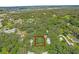 Aerial view showing a lot surrounded by lush trees and neighboring houses at 104 E Mcclendon St, Lady Lake, FL 32159