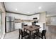 Modern kitchen with white cabinets, stainless steel appliances, and a dining area at 106 Oregon Ave, Saint Cloud, FL 34769