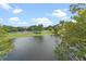 Scenic view of a lake with lush greenery and parking area at 12556 Floridays Resort Dr # 207-A, Orlando, FL 32821