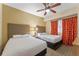 Bright bedroom with two double beds and orange curtains at 12556 Floridays Resort Dr # 207-A, Orlando, FL 32821