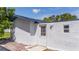 White stucco exterior wall with a door and window at 168 E Sunset St, Groveland, FL 34736