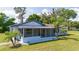 Exterior view of a charming house with a screened porch and landscaping at 168 E Sunset St, Groveland, FL 34736