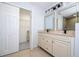 Double vanity bathroom with beige tile floor and walk-in closet at 168 E Sunset St, Groveland, FL 34736