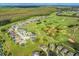 Aerial view of a golf course community with numerous houses and lush green landscaping at 117 Troon Cir, Davenport, FL 33897