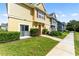 Front view of townhome featuring a red door and manicured lawn at 4560 Yellowgold E Rd # 101, Kissimmee, FL 34746