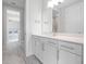 Modern bathroom with white cabinets, quartz countertop and a large mirror at 3198 Sailing Pier Ave, Winter Garden, FL 34787