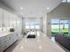 Modern kitchen with white cabinets, expansive island, and backyard views at 3198 Sailing Pier Ave, Winter Garden, FL 34787