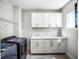 Laundry room with white cabinets, washer, dryer, and utility sink at 3198 Sailing Pier Ave, Winter Garden, FL 34787