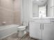 Bathroom with tub and shower, neutral tile, and white vanity at 3198 Sailing Pier Ave, Winter Garden, FL 34787