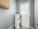 Small laundry room with water heater and cabinets at 1628 S Grove St, Eustis, FL 32726