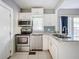 Modern kitchen featuring white cabinets, granite countertops, and stainless steel appliances at 1628 S Grove St, Eustis, FL 32726