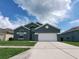 Two-story house with gray exterior, white garage door, and green lawn at 714 Hacienda Cir, Kissimmee, FL 34741